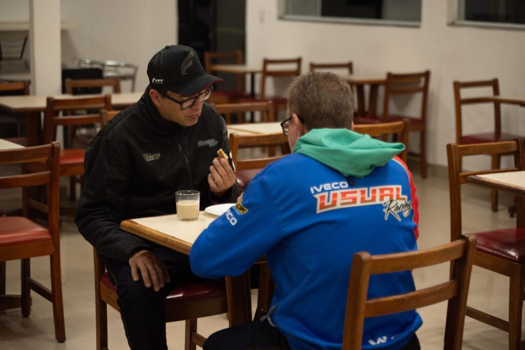 Hóspedes de equipe de corrida tomando café da manhã no salão do hotel